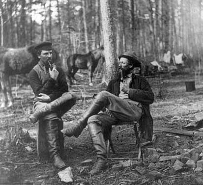 two soldiers smoking pipes in camp